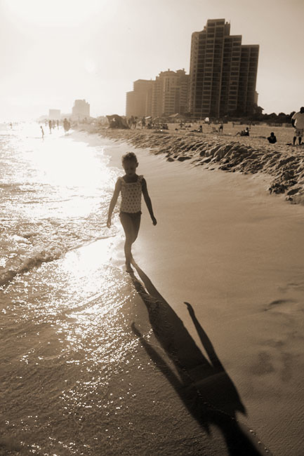 Aut-walking-on-beach-long-shadow-sephia