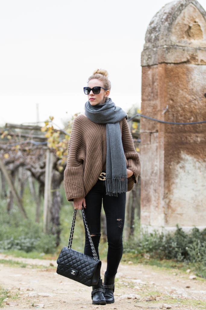 casual-travel-outfit-with-oversized-sweater-and-distressed-black-jeans-Chanel-Jumbo-flap-bag-black-with-silver-hardware